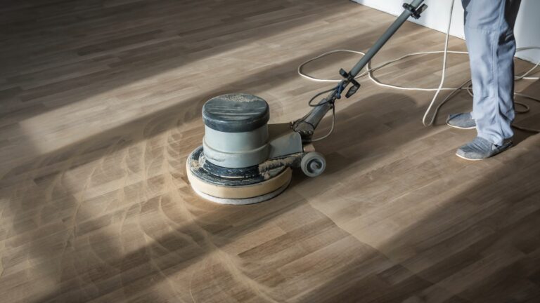 Person using a floor buffer on wooden flooring
