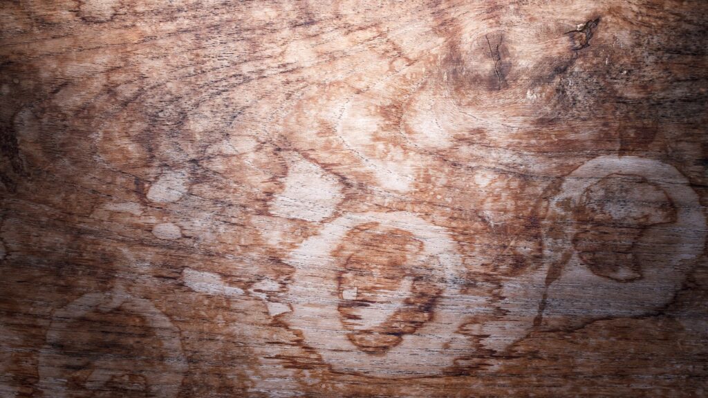 Close-up of a wooden surface with circular stains and textured grain