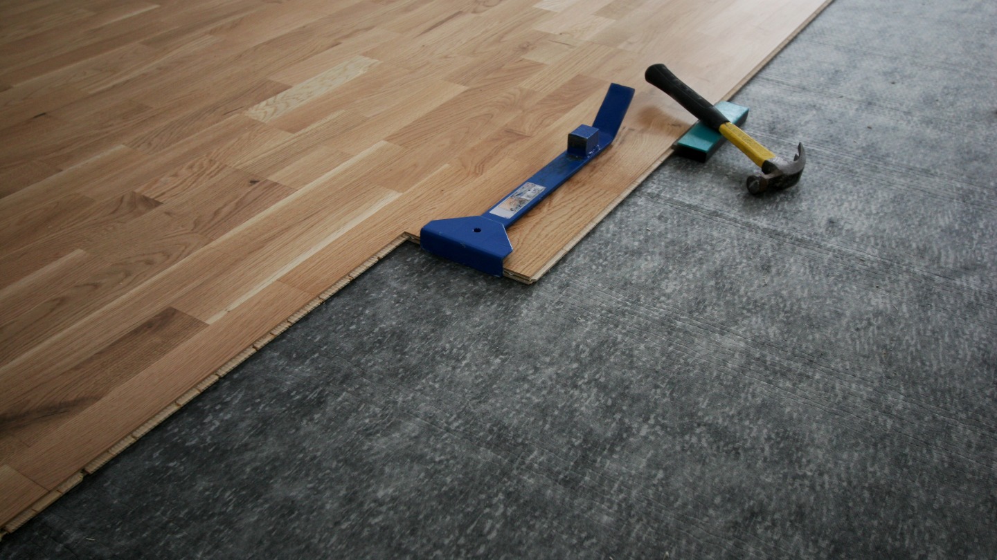 Installation of wooden flooring with tools on a concrete surface